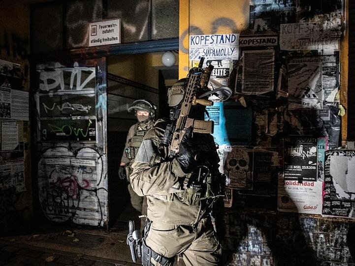 SEK-Beamte gehen bei einer Razzia in der Rigaer Straße in Berlin-Friedrichshain aus einem Haus.