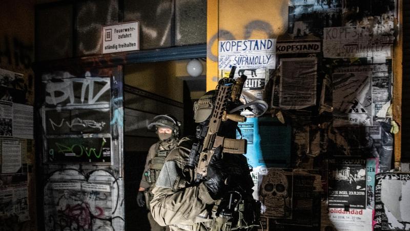 SEK-Beamte gehen bei einer Razzia in der Rigaer Straße in Berlin-Friedrichshain aus einem Haus. SEK-Beamte gehen bei einer Razzia in der Rigaer Straße in Berlin-Friedrichshain aus einem Haus.