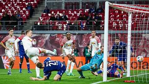 Leipzigs Lukas Klostermann (l) trifft gegen Hoffenheims Torwart Oliver Baumann zum 1:0.