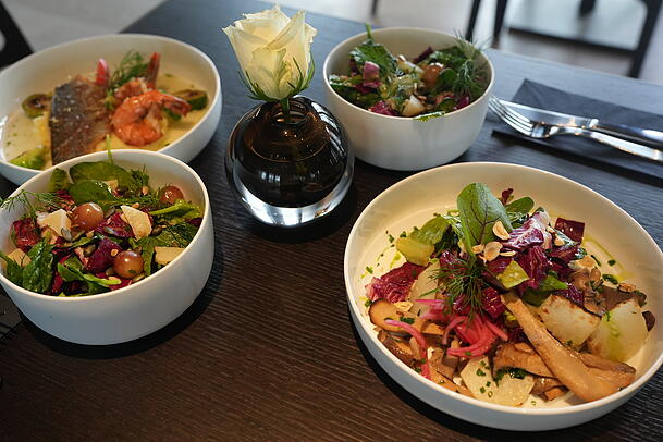 Rechts die vegetarische Buchweizen-Bowl, links die Dorade mit Garnelen, dazu zwei kleine Salate.