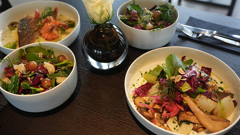 Rechts die vegetarische Buchweizen-Bowl, links die Dorade mit Garnelen, dazu zwei kleine Salate.