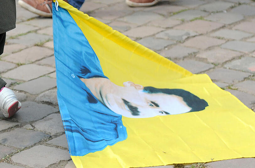 Eine Fahne mit dem Konterfei von Pkk-Gründer Abdullah Öcalan liegt am Rande einer Demonstration auf dem Boden (Archivbild)