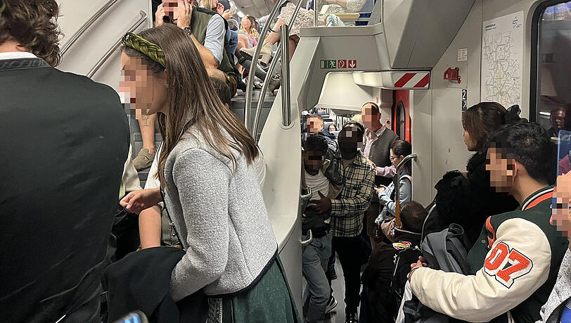 Der junge Mann in der Mitte ist kurz davor, sich zu übergeben. Die Toilette wird allerdings noch von einem Mann in Lederhosen besetzt.