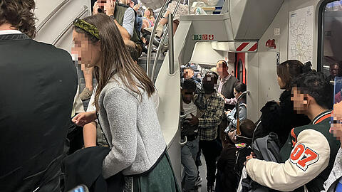 Der junge Mann in der Mitte ist kurz davor, sich zu übergeben. Die Toilette wird allerdings noch von einem Mann in Lederhosen besetzt.