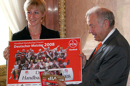 VIP-Karten, Trikot, Fan-Schal und ein gerahmtes Bild mit den FCN-Meisterspielerinnen: Steffi Ofenböck beschenkt Günther Beckstein.