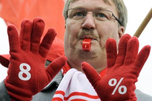 Ein Metaller macht mit Handschuhen seine Forderung deutlich: Die Streikenden wollen acht Prozent mehr Lohn.