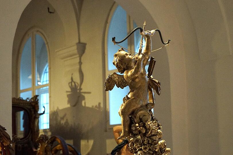 Eine Figur der Amor ziert ein Ausstellungsstück.