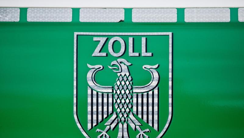 Ein Zollwappen ist auf einem grünem Hintergrund zu sehen. Foto: Daniel Karmann/dpa/Archivbild Ein Zollwappen ist auf einem grünem Hintergrund zu sehen. Foto: Daniel Karmann/dpa/Archivbild