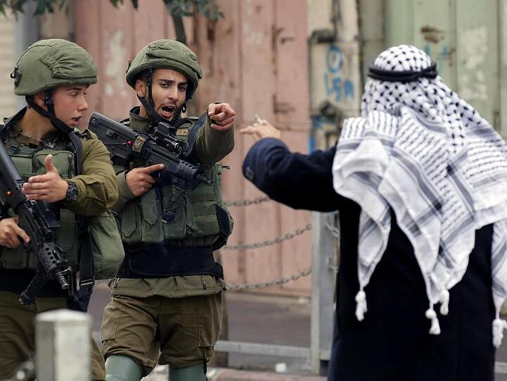 Ein Mann streitet in Hebron im Westjordanland mit israelischen Soldaten.