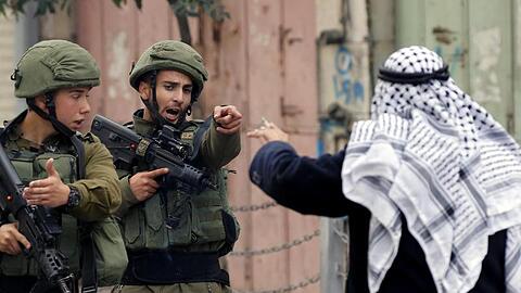 Ein Mann streitet in Hebron im Westjordanland mit israelischen Soldaten.