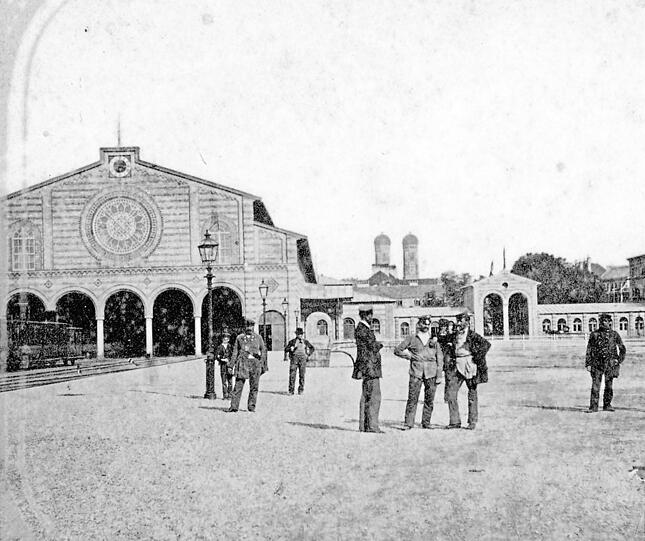 1860 am alten Hauptbahnhof mit Blick Richtung Altstadt: Personal und Fahrg&auml;ste warten auf den Zug.