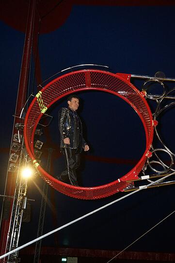 Crazy Wilson aus Kolumbien ist das akrobatische Highlight der Krone-Evolution. Er schwebt auf den Flügeln des Todesrades und zeigt auf dem &bdquo;Fliegenden Motorrad&ldquo; - mit viel Adrenalin im Blut &ndash; den gefährlichsten Ritt aller Zeiten.Einsamer Höhepunkt ist der Salto Mortale auf dem Außenrad in 10 Meter Höhe bei 120 km/h im UV-Licht.