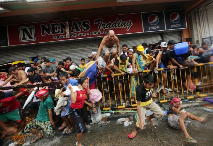 Opfer sammeln sich in der Stadt Tacloban vor einem Laden: Die Notversorgung rollt nur schleppend an, weil Flughäfen, Häfen und Straßen schwer beschädigt sind. Die Polizei warnt vor Plünderungen, aber die sind in vollem Gange.