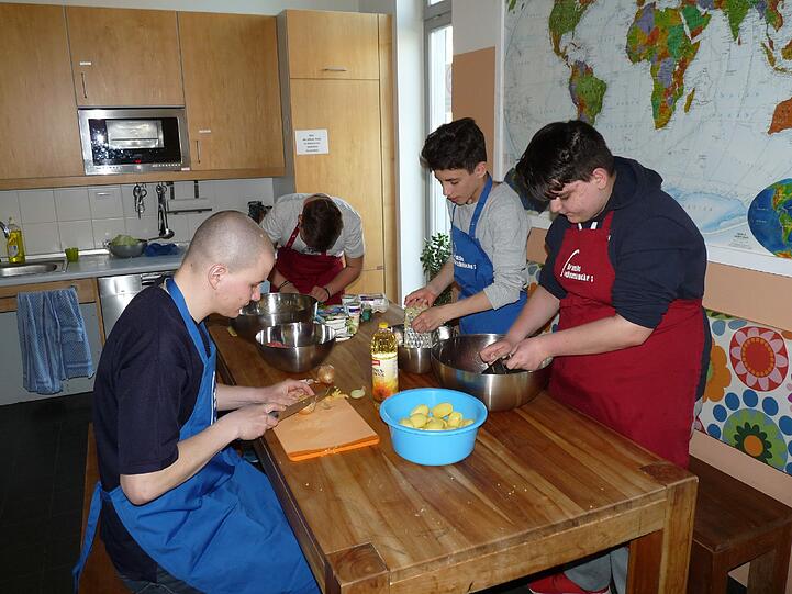 Cvijo (l.) beim Kochen mit seinen Schützlingen.