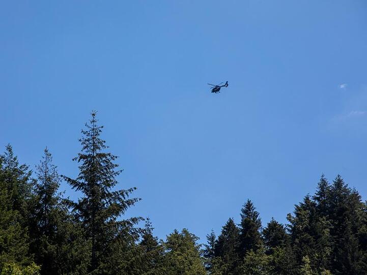 Ein Hubschrauber der Polizei schwebt nahe Oppenau in der Luft. Ein mit Pfeilen und Bogen bewaffneter Mann hat in dem Ort im Schwarzwald Polizisten bedroht und ihnen die Waffen abgenommen.
