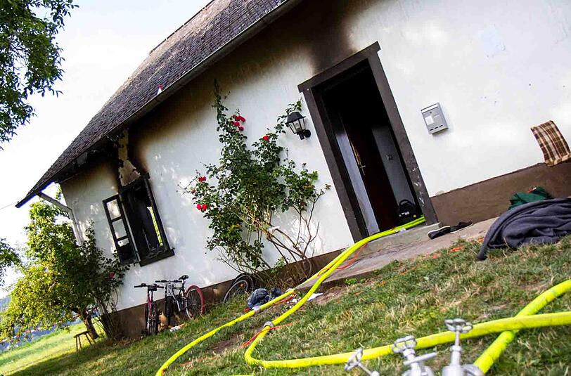 Wasserschläuche der Feuerwehr liegen vor der Flüchtlingsunterkunft in Rüdesheim, nachdem bei einem Brand zuvor ein Mann ums Leben gekommen war. Foto: Wiesbaden112.de/dpa