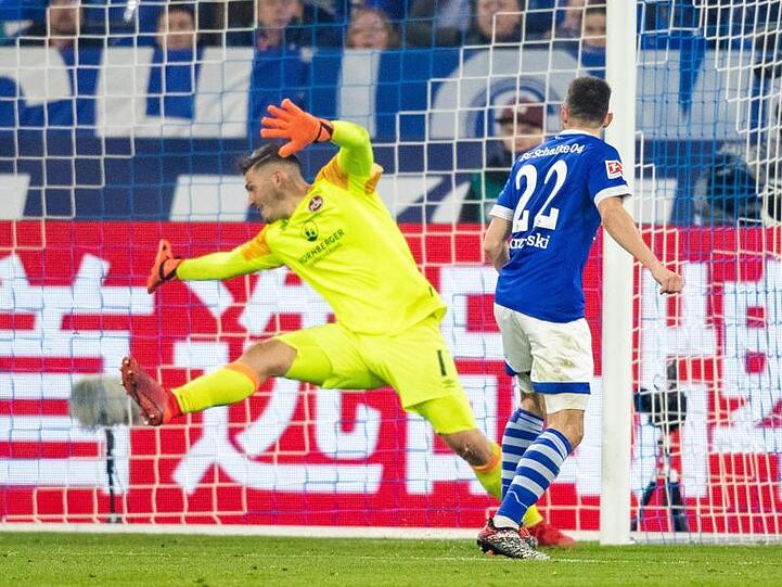 Schalkes Steven Skrzybski (r) schießt den Ball zum 4:2 ins Tor von Nürnbergs Torwart Fabian Bredlow (m). Foto: Marcel Kusch
