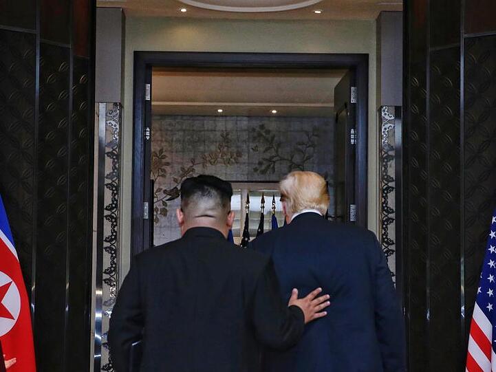 Der Machthaber von Nordkorea Kim Jong Un legt U.S. Präsident Donald Trump die Hand auf die Schulter nach der Unterzeichnung einer Vereinbarung.