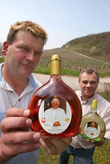 Auch für gläubige Wein-Liebhaber gibt es das pasende Tröpfchen: Winzer Frank Schmidt (links) und Getränkehändler Klaus Hilf präsentieren 2006 in den Weinbergen bei Bullenheim/Unterfranken eine rote und eine weiße Version des sogenannten "Papstweines".