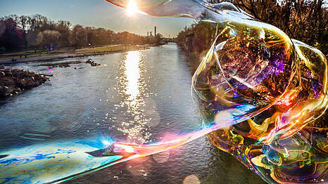 Die tief stehende Wintersonne taucht die Isar in ein magisches Licht, eine riesige Seifenblase schillert in der Sonne &ndash; passend zu den besonderen Tagen zwischen den Jahren.