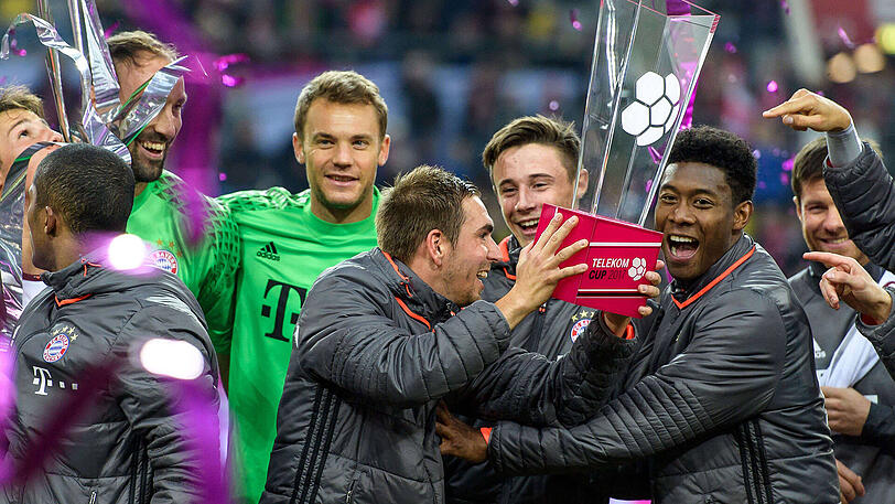 Philipp Lahm und David Alaba mit der Trophäe in der Mitte.