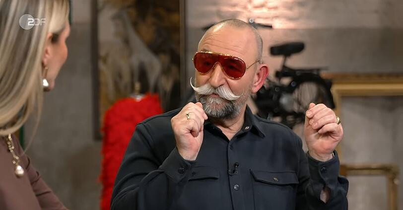 Der Gastgeber lie&szlig; sich nicht zweimal bitten: Kurzerhand setzte er das extravagante Modell selbst auf.