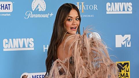 Rita Ora zog sich während der Veranstaltung in Manchester gleich mehrfach um. Auf dem roten Teppich präsentierte sie ein staubrosanes Federkleid.