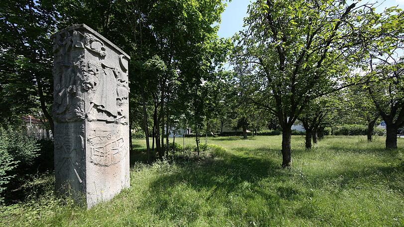 Diese Stele steht inmitten von Obstbäumen.
