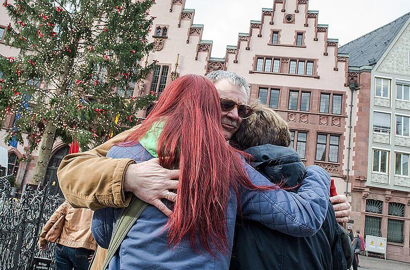 Eine Familie nimmt auf dem Römerplatz in Frankfurt am Main an der europaweiten Schweigeminute für die Opfer der Terroranschläge in Paris teil.