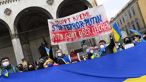 Demonstranten mit einem Plakat "Stoppt Kreml, Stoppt Terror Putin, Putin geht über Leichen" am Odeonsplatz.