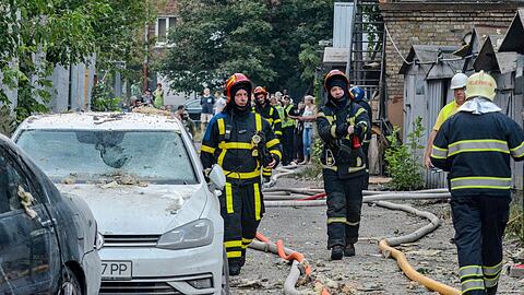 Feuerwehrleute löschen nach einem Raketenangriff auf Kiew ein Feuer.