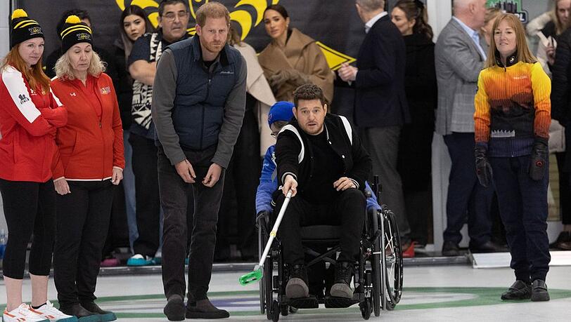 Voller Einsatz: Michael Bublé probierte neben Prinz Harry Rollstuhl-Curling aus. Im Hintergrund schaute Meghan zu.