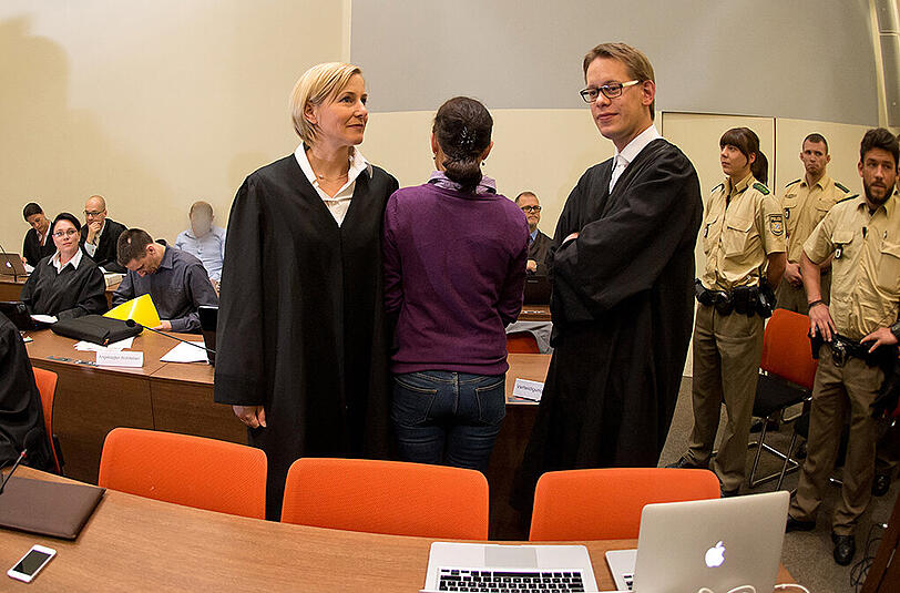 Die Angeklagte Beate Zschäpe (M.) steht am 10.07.2014 im Gerichtssaal in München zwischen ihren Anwälten Anja Sturm (l) und Wolfgang Heer.