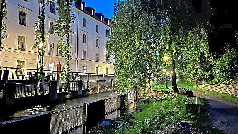 Am Neudeck entlangspazieren entwickelt in den Abendstunden noch mal einen besonderen Reiz. Das Licht der Laternen scheint durch die Weiden hindurch zu glitzern, der Bach rauscht vorbei – auf den Bankerl kann man wunderbar innehalten.