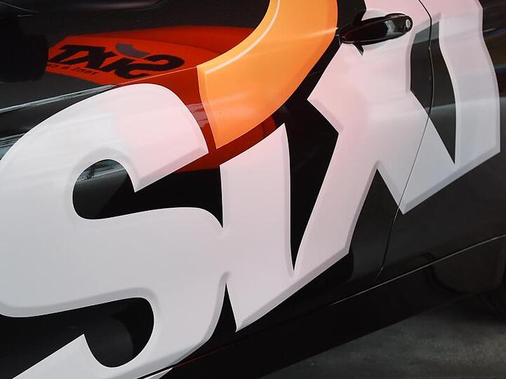 Das Logo des Autovermieters Sixt SE an einer Fahrzeugtür. Foto: Tobias Hase/dpa/Symbolbild
