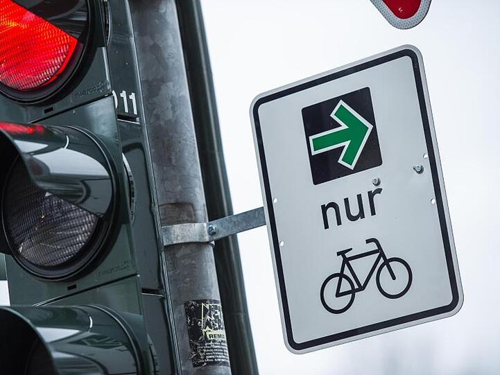 An einer Ampel einer Kreuzung hängt ein sogenannter grüner Pfeil für Radfahrer. Foto: Christophe Gateau/Archiv