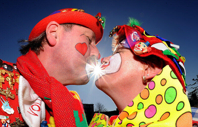 Zwei Narren geben sich am Montag (07.03.2011) beim Rosenmontagszug in Düsseldorf bei strahlenden Sonnenschein ein Bützchen (Küsschen). Am elften Elften um elf Uhr elf beginnt die neue Karnevalssession.