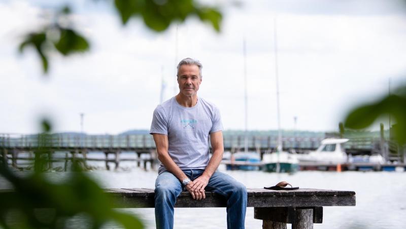 Hannes Jaenicke, Schauspieler, sitzt bei einem Fototermin auf einem Steg am Ammersee. Foto: Sven Hoppe/dpa/Archivbild