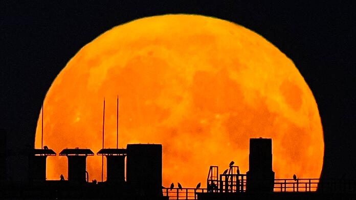 Ein Supermond geht über einem Wohnhaus auf. Ein Supermond geht über einem Wohnhaus auf.