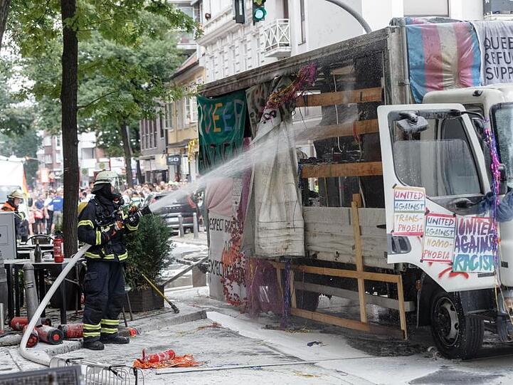 Feuerwehrmänner löschen den Truck, der bei der CSD-Parade zum Christopher Street Day Feuer fing.