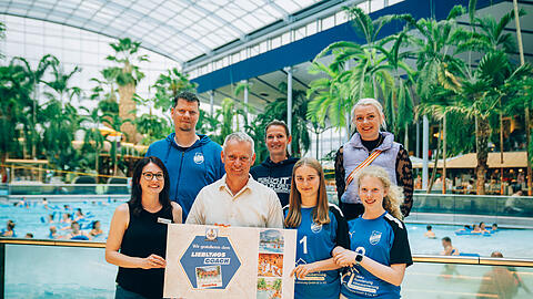 So sehen Sieger aus: Karolin Hönsch (links) von der Therme Erding überreicht dem glücklichen Gewinner Berhard "Bergi" Bergmoser den Preis für die Wahl zum Lieblingscoach. Mit ihm freuen sich seine Trainerkollegen und die Mannschaft, die er beim TSV Eintracht Karlsfeld e.V. trainiert.