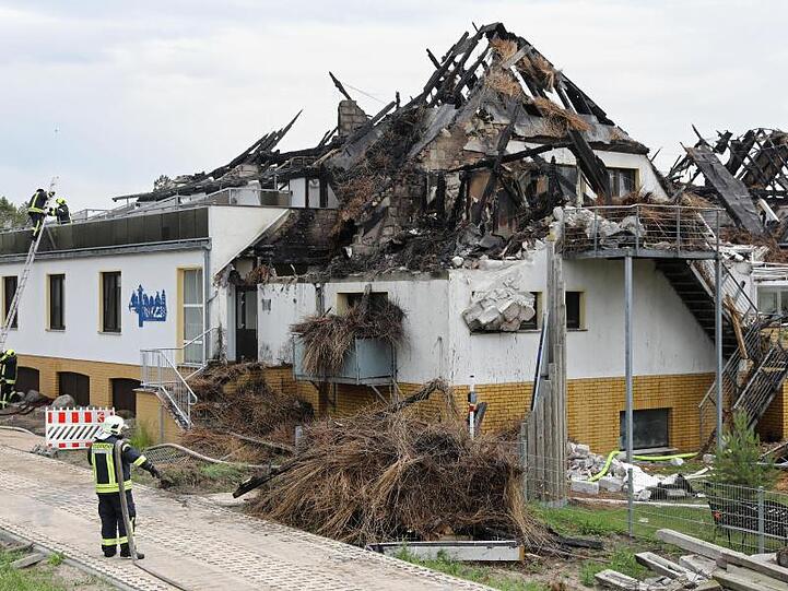 Feuerwehrleute sind bei Kontroll- und Aufräumarbeiten am ausgebrannten Ostseehotel auf der Halbinsel Fischland-Darß-Zingst.