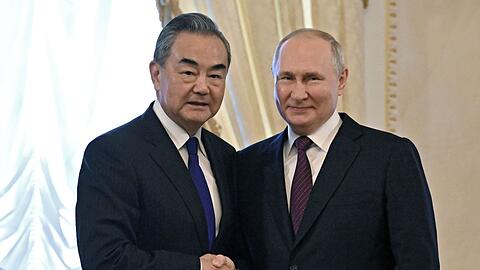 Wladimir Putin und empfängt Chinas Außenminister Wang Yi im Konstantin-Palast in St. Petersburg.