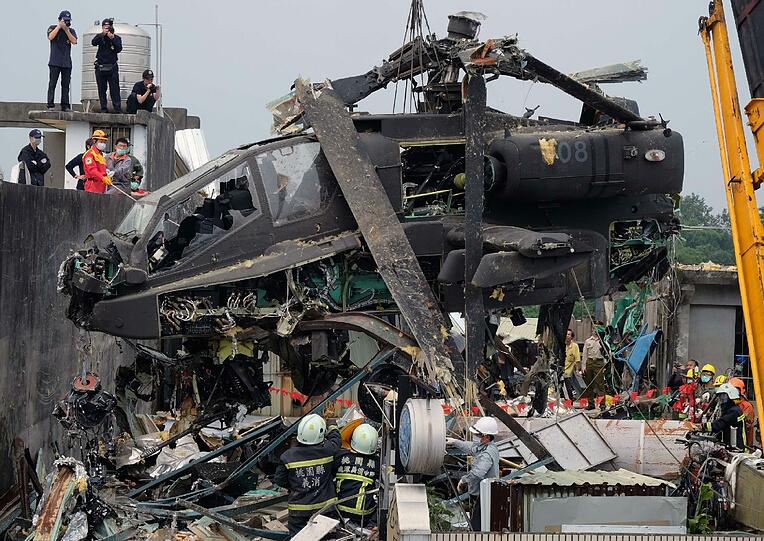Taiwanesische Arbeiter beseitigen einen geschrotteten US-Helikopter von einem Hausdach in Taoyuan. Die zwei taiwanesische Piloten stürzten während einer militärischen Übung ab und verletzten sich schwer.