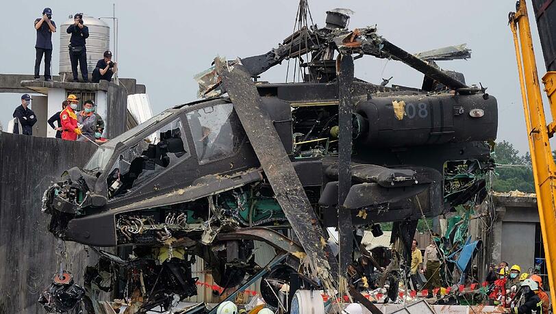 Taiwanesische Arbeiter beseitigen einen geschrotteten US-Helikopter von einem Hausdach in Taoyuan. Die zwei taiwanesische Piloten stürzten während einer militärischen Übung ab und verletzten sich schwer. Taiwanesische Arbeiter beseitigen einen geschrotteten US-Helikopter von einem Hausdach in Taoyuan. Die zwei taiwanesische Piloten stürzten während einer militärischen Übung ab und verletzten sich schwer.