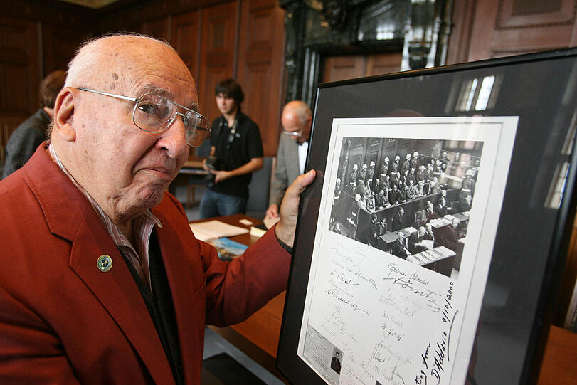 Ray D&rsquo;Addario hält ein Foto mit den Unterschriften der angeklagten Nazis in der Hand.