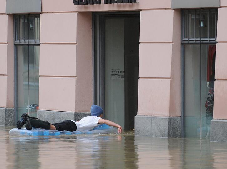 Letzte Rettung Luftmatratze: Ein junger Mann paddelt durch die Passauer Altstadt.  Die Lage dort ist weiter dramatisch.
