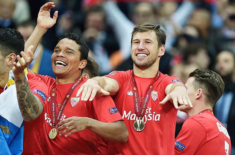 Grzegorz Krychowiak (m) und Carlos Bacca (l) vom FC Sevilla im Freudentaumel