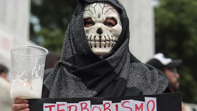 Eine Demonstrantin trägt bei einem Protestzug für Ermittlungen zum Mord an Rubén Espinosa ein Schild mit der Aufschrift "Staatsterrorismus". Kritiker unterstellen dem Gouverneur von Veracruz, Javier Duarte, eine Verstrickung in den Fall. Eine Demonstrantin trägt bei einem Protestzug für Ermittlungen zum Mord an Rubén Espinosa ein Schild mit der Aufschrift "Staatsterrorismus". Kritiker unterstellen dem Gouverneur von Veracruz, Javier Duarte, eine Verstrickung in den Fall.