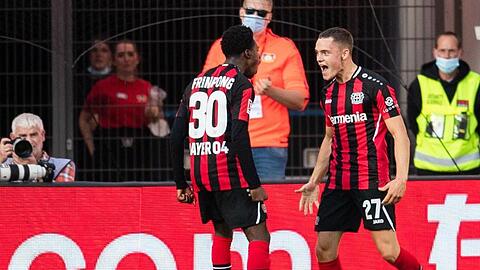 Leverkusens Jeremie Frimpong (l) und Torschütze Florian Wirtz jubeln nach dem Treffer zum 1:0.